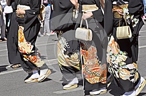 Japanese women in black kimano are walking down the street