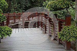 A Japanese wooden bridge in a garden over a lake