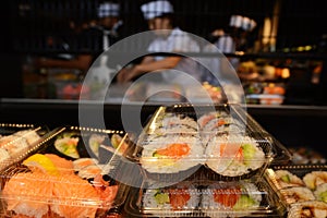 Japanese workers prepare Sushi rolls