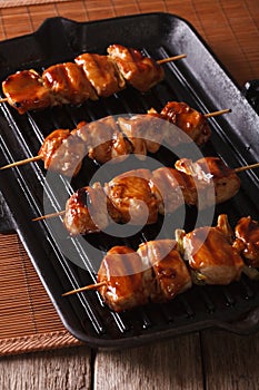 Japanese yakitori skewers of chicken on a grill. vertical close-up