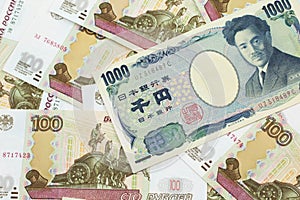 A Japanese yen bank note with Russian one hundred ruble bills