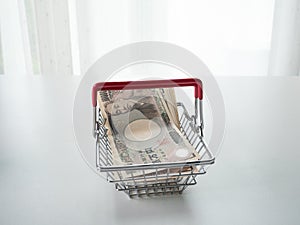 Japanese Yen in basket on white background