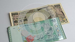 Japanese yen and Malaysia ringgit bank notes. 10000 Yen and fifty ringgit.