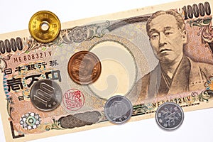 A Japanese 10000 yen note and coins are on a white background. Close-up