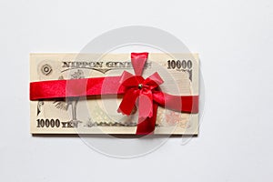 Japanese yen with the red bow on white background Concept for c