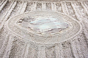 Japanese zen garden meditation stone in lines sand