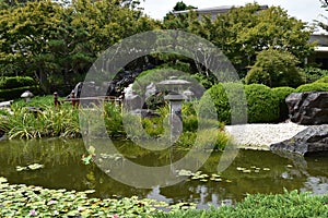 Japanese zen garden pond with bridge and stone lamp