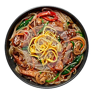 Japchae in black bowl isolated on white. Korean cuisine glass chapchae noodles dish with vegetables and meat