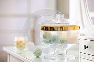 Jar with bath bombs and bath sponge on table