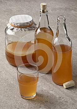 Jar, bottle and glass with Kombucha drink close up