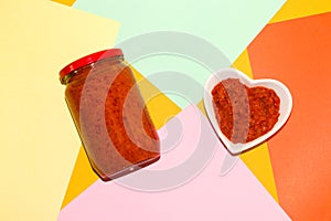 jar and bowl of ajvar on a colorful background, traditional Balkan dish, roasted pepper and eggplant sauce