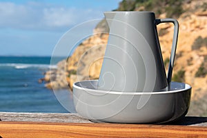 Jar in a bowl with ocean and a cliff as a background. Australia, Barwon Heads