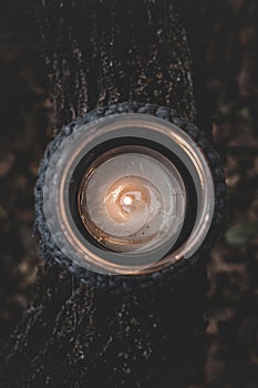 Jar with a burning candle decorated with knitted macrame