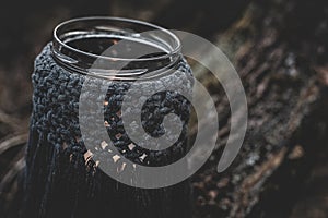 Jar with a burning candle decorated with knitted macrame