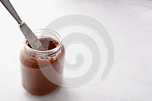 Jar of chocolate-nut paste spread and toast with copy space