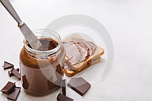 Jar of chocolate-nut paste spread and toast with copy space