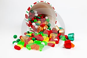 Jar of christmas candy spilled isolated in white background