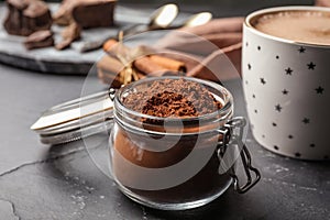 Jar of cocoa powder on grey table