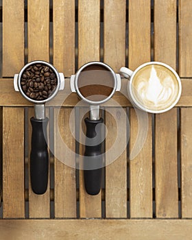 Jar of coffee, a coffee maker`s horn on wood background, top view