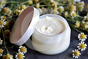 A jar of cosmetic cream with chamomile