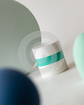 A jar of cosmetics and abstract shapes on a white background. Cosmetics. Minimalism