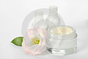 Jar with cream and bottles on white background.