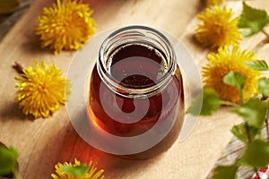 A jar of dandelion honey - syrup made from fresh dandelion flowers in spring