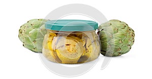 Jar of delicious artichokes pickled in olive oil and fresh vegetables on white background