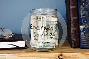 Jar with Emergency savings Cash Fund on a shelf.