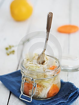 Jar with fermented cabbage and carrots. Harvested, pickled, canned vegetarian food, concepts. Cabbage, dill, carrots, peppers.