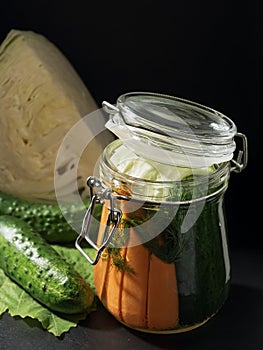 Jar with fermented vegetables. Fermented, canned vegetarian food concept. Cabbage, cucumber, dill, markov. Sauerkraut in a glass