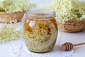 A jar filled with fresh elder flowers and honey, to prepare syrup
