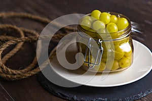 Jar of fresh grapes with handmade rope on an old basis