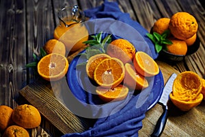 jar of fresh pressed oranges with mint on the table with blue cloth