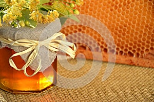 Jar full of delicious fresh honey linden flowers and honeycomb frame