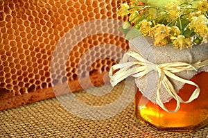 Jar full of delicious fresh honey linden flowers and honeycomb frame