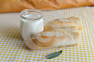 Jar with Greek yoghurt and a crispy French baguette