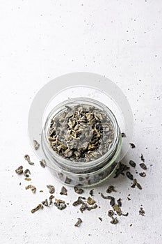 Jar of green tea on white surface, taken from above