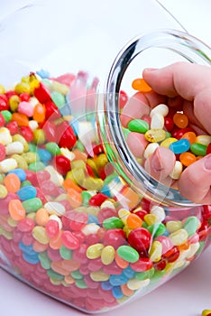 Jar and handful of jelly beans photo