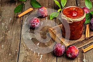 Jar with homemade plum jam on a wooden background. banner, menu, recipe place for text