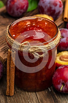 Jar with homemade plum jam on a wooden background. banner, menu, recipe place for text