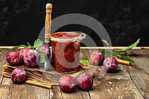 Jar with homemade plum jam on a wooden background. banner, menu, recipe place for text