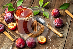 Jar with homemade plum jam on a wooden background. banner, menu, recipe place for text