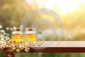 Jar of honey and chamomile on a wooden table with green fields in the background