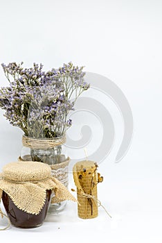 Jar of honey with dried flowers of Calluna vulgaris or heather and beeswax candle for background and decoration