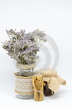 Jar of honey with dried flowers of Calluna vulgaris or heather and beeswax candle for background and decoration