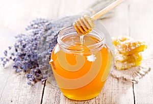 Jar of honey with honeycomb and lavander flowers photo