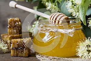 Jar with honey, honeycomb with pollen and linden flowers