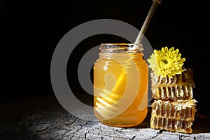 Jar of honey and honeycombs on a wooden background