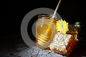 Jar of honey and honeycombs on a wooden background